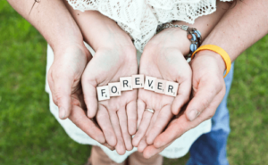 아이의 손바닥 위에 forever 라는 글자 카드가 놓여 있는 모습